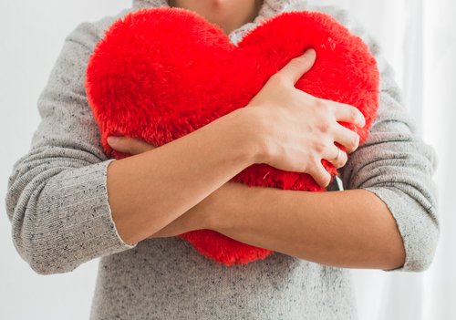 woman holding heart pillow 